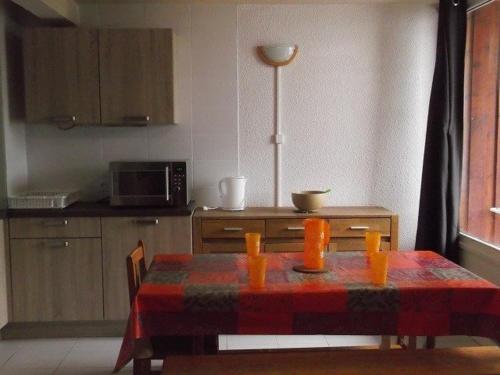 une cuisine avec une table et des bougies orange. dans l'établissement Appartement spacieux 3 pièces, 8 pers, 20m des pistes, proche commerces et loisirs, Orcières - FR-1-262-92, à Forest des Baniols