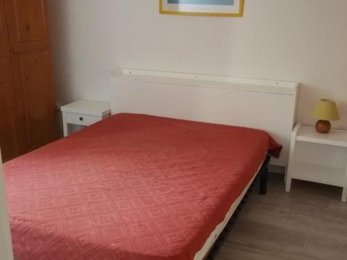 a small bedroom with a bed with a red bedspread at Appartement Orcières Merlette, 3 pièces, 8 personnes - FR-1-262-92 in Forest des Baniols