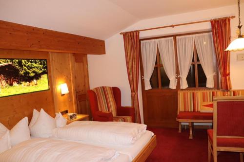 a hotel room with a bed and a table and chairs at Zum Eichhof in Reit im Winkl
