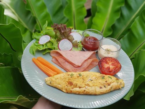 une plaque de nourriture contenant de la viande et des légumes dans l'établissement Nua Tone Resort Bang Tao & Cafe, à Bang Tao Beach