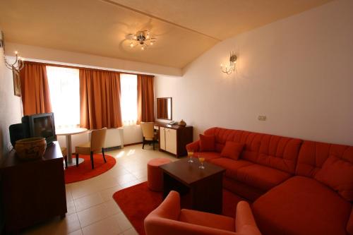 a living room with a red couch and a table at Villa Segetski dvori - Tradition since 1964 in Trogir