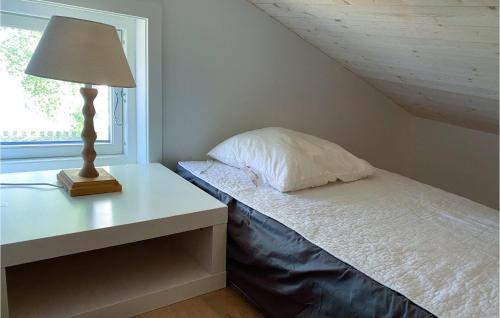 a bedroom with a bed with a lamp and a window at Beautiful Home In Gotlands Tofta With Kitchen in Gnisvärd