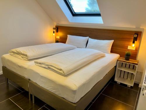 um quarto com uma cama grande e uma clarabóia em JUNIPRO Apartments & Rooms em Nohfelden