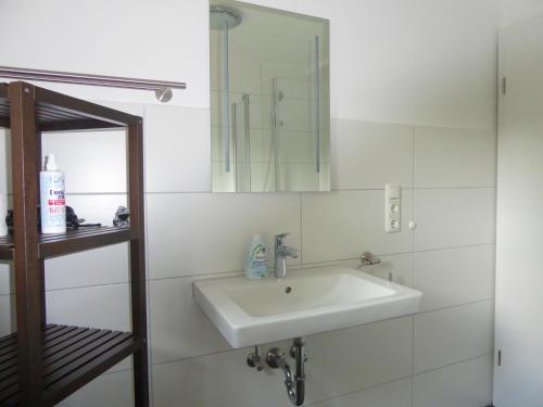 een witte badkamer met een wastafel en een spiegel bij Paris Winterberg Ferienwohnung 6 Pers WiFi in City near Lift in Winterberg