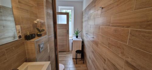 a bathroom with a large wooden wall with a shower at Lake Room Ełk in Ełk