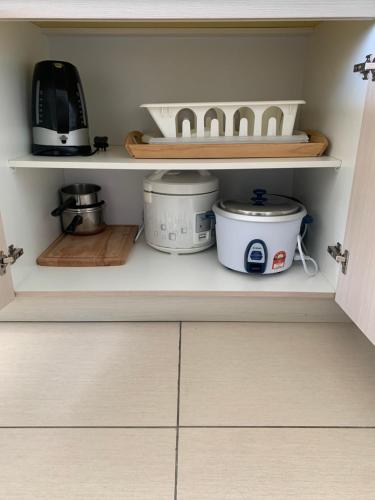 a kitchen shelf with pots and pans on it at Cloud 9 Suite - Midhills Genting Highland in Genting Highlands