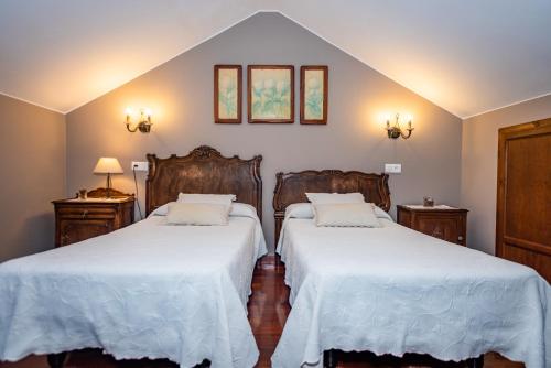 a bedroom with two beds with white sheets at Casa Rural Ablanos de Aymar in Loroñe