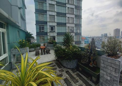 uma varanda com plantas e um edifício alto em Khai Hoan Apartment Hotel em Ho Chi Minh