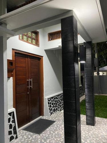 a house with a wooden door in a yard at Villa Syamsu in Bukittinggi