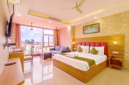 a bedroom with a large bed and a living room at The Glory Hotel in Dehradun