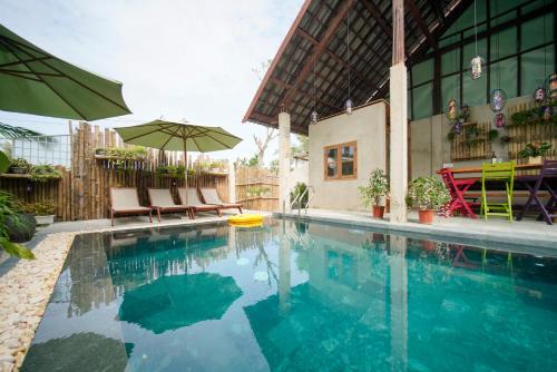 basen z krzesłami i parasolem w obiekcie HA Devan Hoian Pool Villa w Hoi An