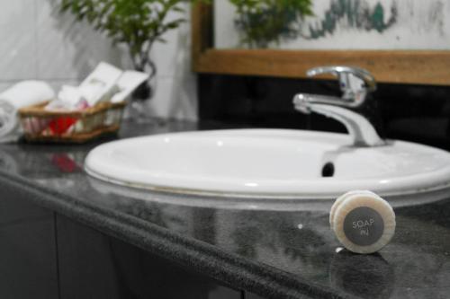 a white bathroom sink with a faucet on a counter at Koimala Hotel in Maamigili