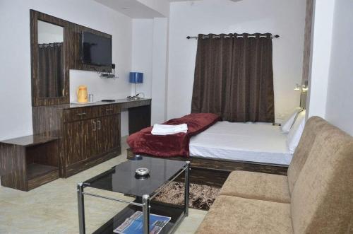 a living room with a bed and a couch at Hotel Kanha Inn in Lucknow