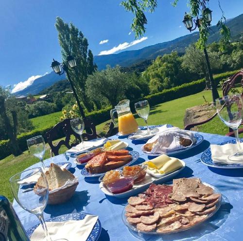 a blue table with plates of food and wine glasses at Mas D'en Roqueta in Aravell