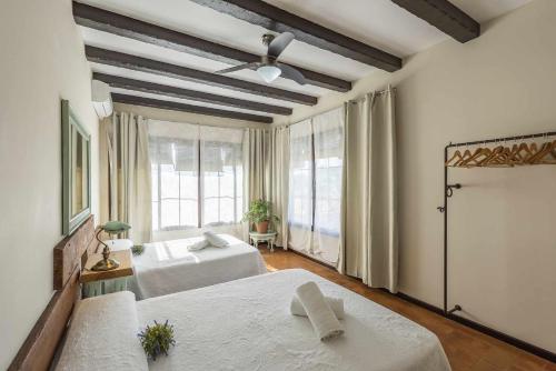 una camera con due letti e una grande finestra di Casa Rural La Teja a Marchena