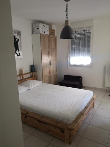 une chambre avec un lit, une fenêtre et une chaise dans l'établissement Magnifique T2 les pieds dans le sable, au Grau-du-Roi