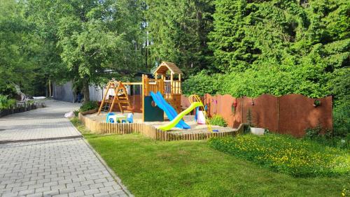 a backyard with a playground with a slide at Pension Kricklsäge in Philippsreut