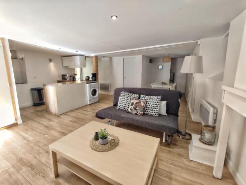 un salon avec un canapé et une table dans l'établissement Le Bigourdan et son Jacuzzi, à Bagnères-de-Bigorre