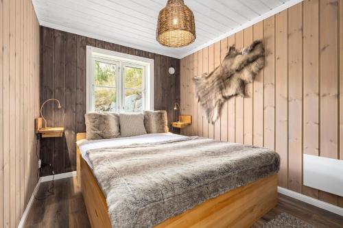 ein Schlafzimmer mit einem Bett in einem Zimmer mit Holzwänden in der Unterkunft Libehi in Lona