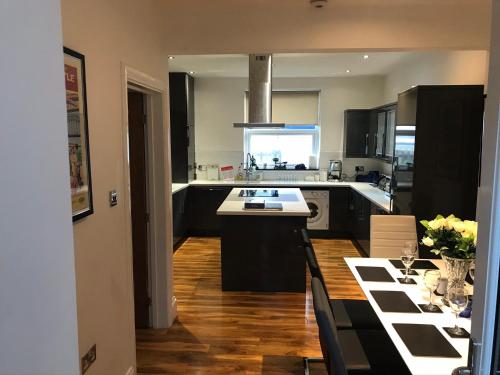 a kitchen with black cabinets and a white counter top at The View in Tynemouth