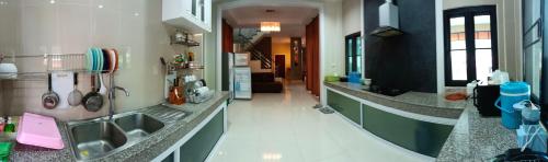 a kitchen with green and white counters and a sink at Preme House Boutique in San Sai