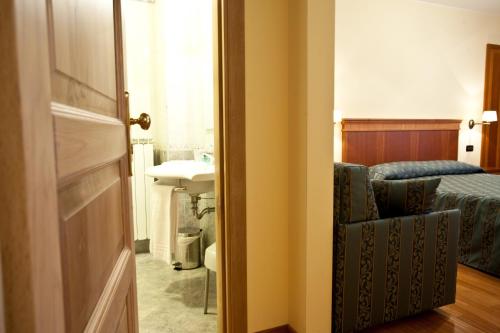 ペスココスタンツォにあるAlbergo Lo Scrignoのバスルーム(ベッド1台、シンク、ドア付)