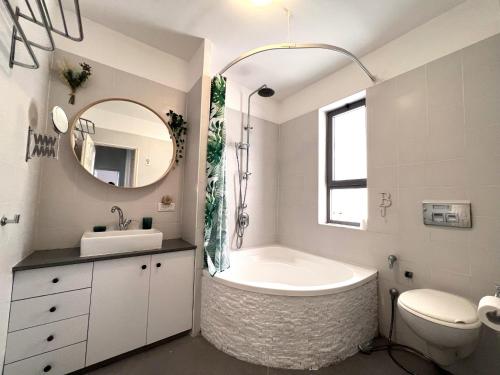 La salle de bains est pourvue d'une baignoire, d'un lavabo et d'un miroir. dans l'établissement Design & Balcony in City Center by FeelHome, à Tel Aviv