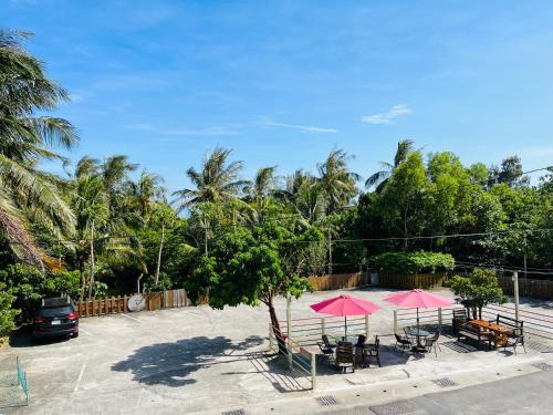 a group of tables and pink umbrellas in a parking lot at 墾丁儷庭民宿Li Ting B&B in Kenting