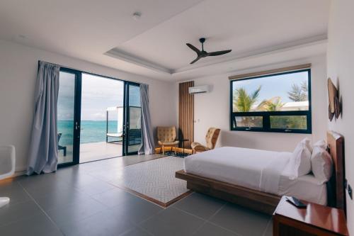 a bedroom with a bed and a view of the ocean at Safira Blu Luxury Resort & Villas in Nungwi