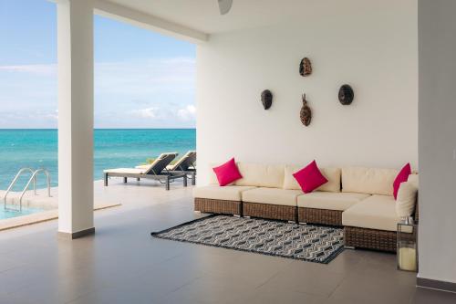 a living room with a couch and a view of the ocean at Safira Blu Luxury Resort & Villas in Nungwi