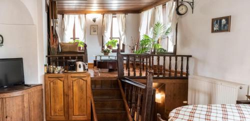 a room with a staircase and a bed and a television at Kazasovata Guest House in Tryavna