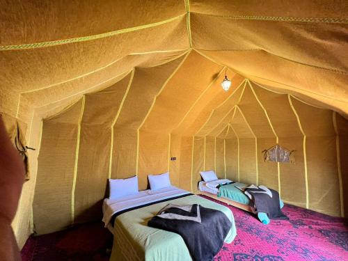 a bedroom with a bed in a tent at Candy Camp in Merzouga