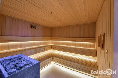 a sauna with a tub in a wooden room at Apartamenty BalticON Polanki Aqua in Kołobrzeg