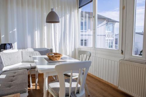 uma sala de estar com uma mesa e cadeiras e um sofá em Villa Meeresblick em Sassnitz