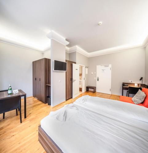 a large white bedroom with a bed and a desk at BoardingWorld Heidelberg in Heidelberg