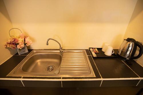 a kitchen counter with a sink and a coffee pot at Lily Holiday 百合假日 in Patong Beach
