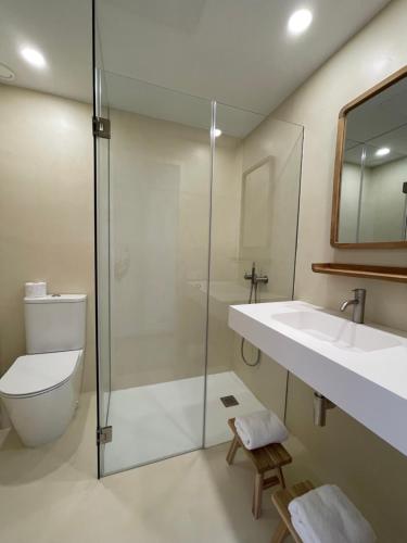 a bathroom with a shower and a sink and a toilet at Habitatges Turístics Riba Pitxot - Norai in Cadaqués