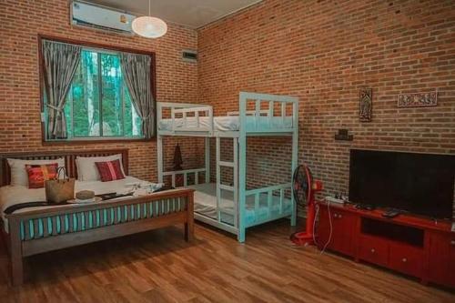 a living room with two bunk beds and a flat screen tv at Nan De Panna Resort and Spa in Nan