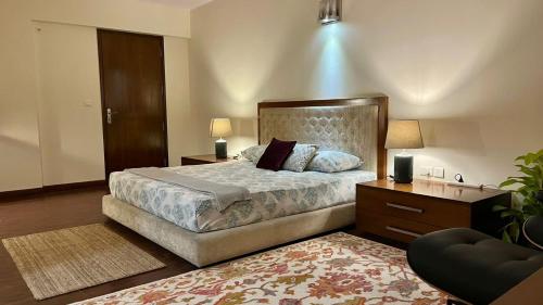 a bedroom with a large bed and a dresser and lamp at LUHO Grande in Bangalore