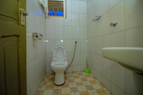 a bathroom with a toilet and a sink at Ambassador Bridge Motel in Jinja