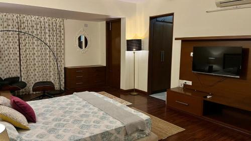 a bedroom with a bed and a flat screen tv at LUHO Grande in Bangalore