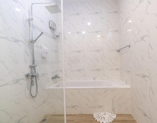 a white bathroom with a shower and a sink at Utapao sattahip rayong resort in Ban Nong Sa