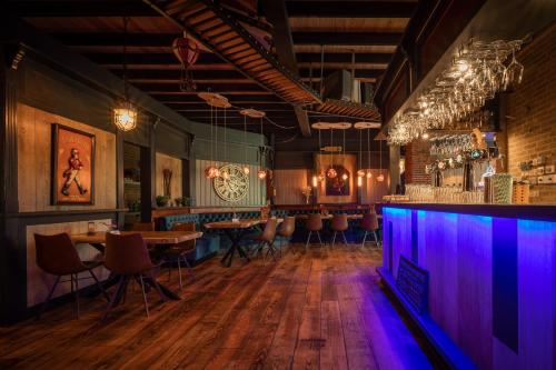 a restaurant with tables and a bar with purple lights at Bungalow - 6 Persons in Hellendoorn