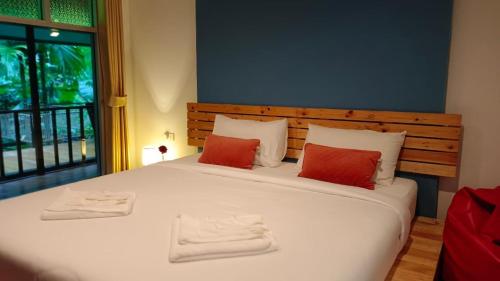1 dormitorio con 1 cama blanca grande y 2 toallas en Nua Tone Resort Bang Tao & Cafe en Bang Tao Beach