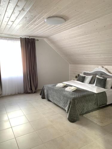 sypialnia z dużym łóżkiem i oknem w obiekcie Café Chalet Edelweiss Holiday Home w mieście Zbarazh