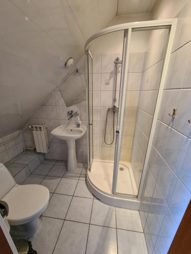 a bathroom with a shower and a toilet and a sink at Gościniec Halka in Zwardoń