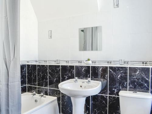 ein Badezimmer mit einem Waschbecken, einem WC und einem Spiegel in der Unterkunft Church View in Cockermouth