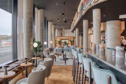 Smarthotel Bodø في بودو: وجود بار في المطعم مع الكراسي والطاولات