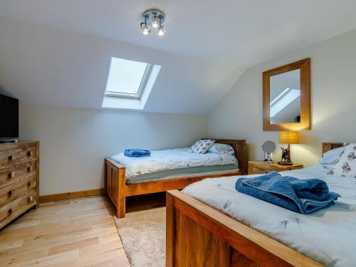 1 dormitorio con 2 camas individuales y espejo en Barn View, en Clay Cross