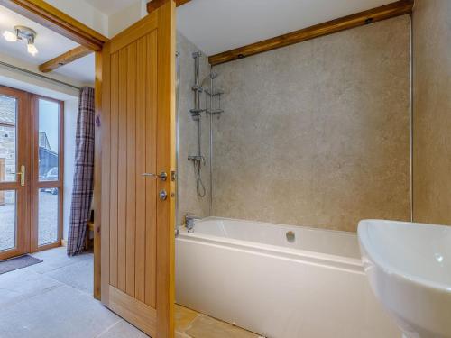 a bathroom with a tub and a sink at Barn View in Clay Cross